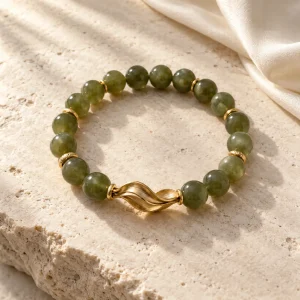 Concept illustration: muted olive green bead bracelet with brushed gold tone accent, gentle wind inspired. Not an actual product photograph.